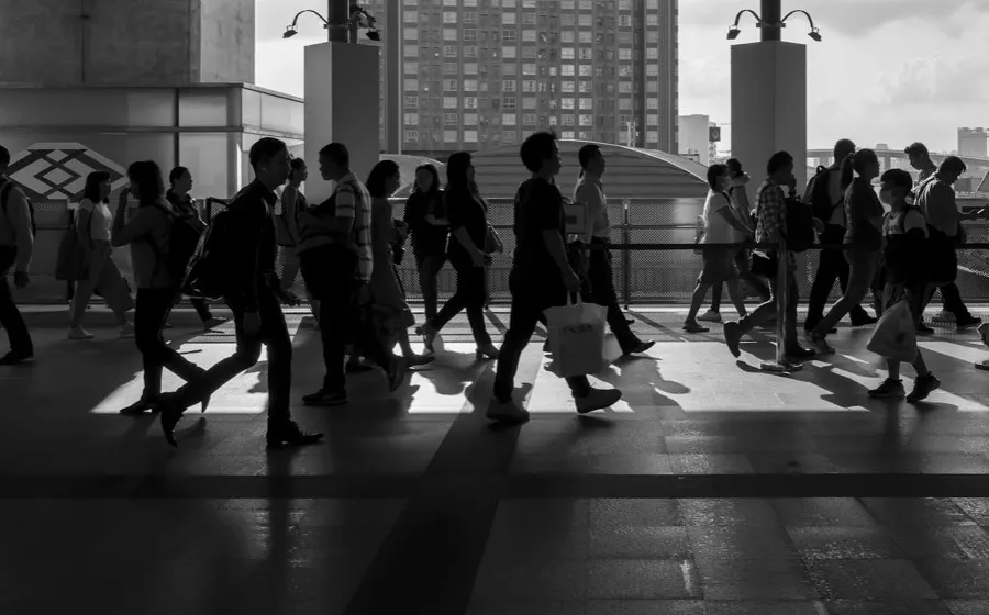 People walking through a station in backlight